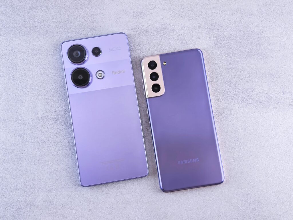 Detailed image showcasing two purple smartphones on a light surface.