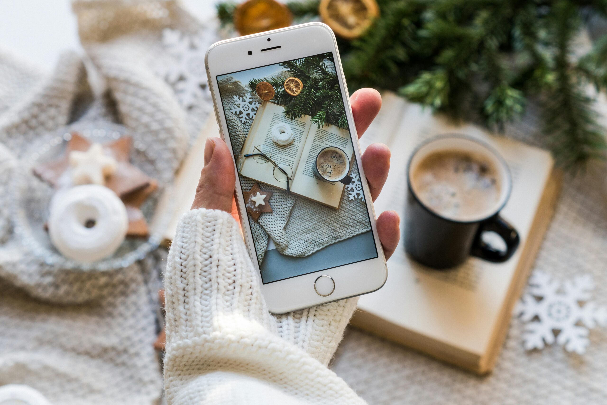 Top view of cozy winter setting with coffee, smartphone capturing a warm flat lay.